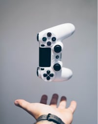 Hand throwing a white PS controller in the air